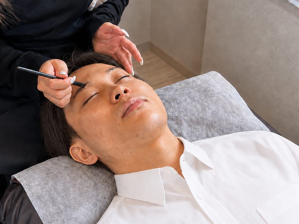 moteteのスタッフが男性のお客様の眉を整えている様子